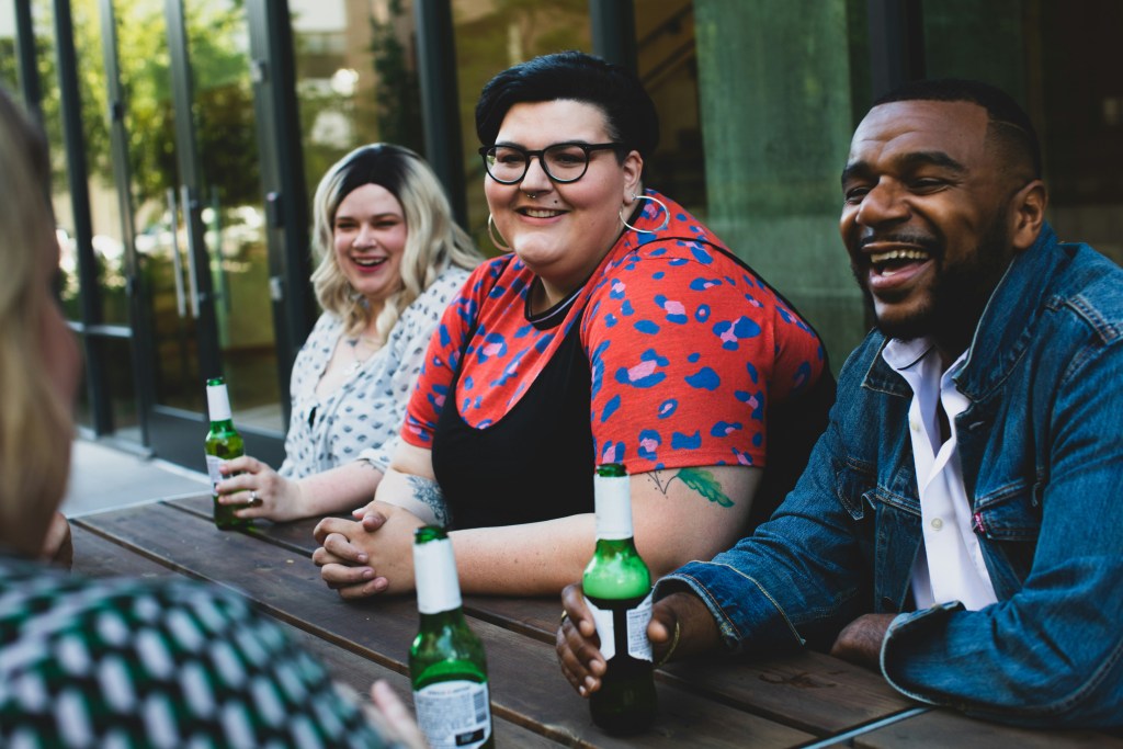 3 people holding beers