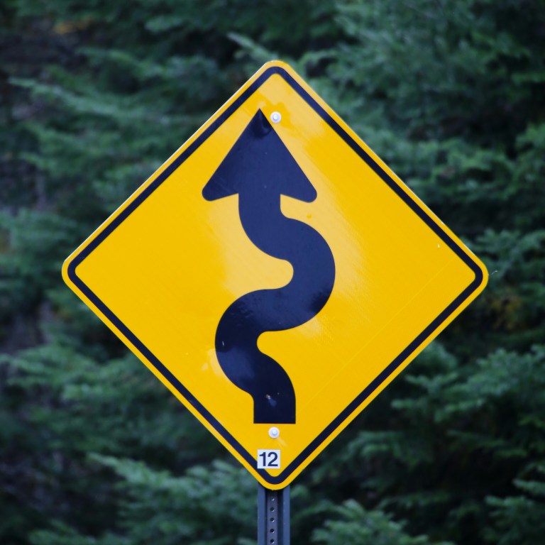 black arrow on yellow background road sign