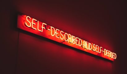 neon sign reading self described and self defined
