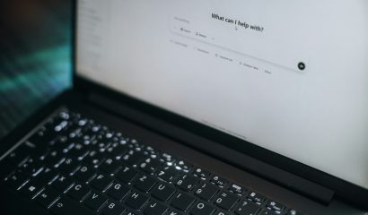 Laptop open with a ChatGPT prompt asking What Can I Help With?
