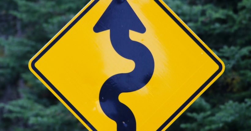 black arrow on yellow background road sign